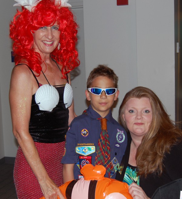 REALTORS® Nancy Marchman (left) and Jenni "JenniMac" McFarland spend time with a boy scout who came to the event